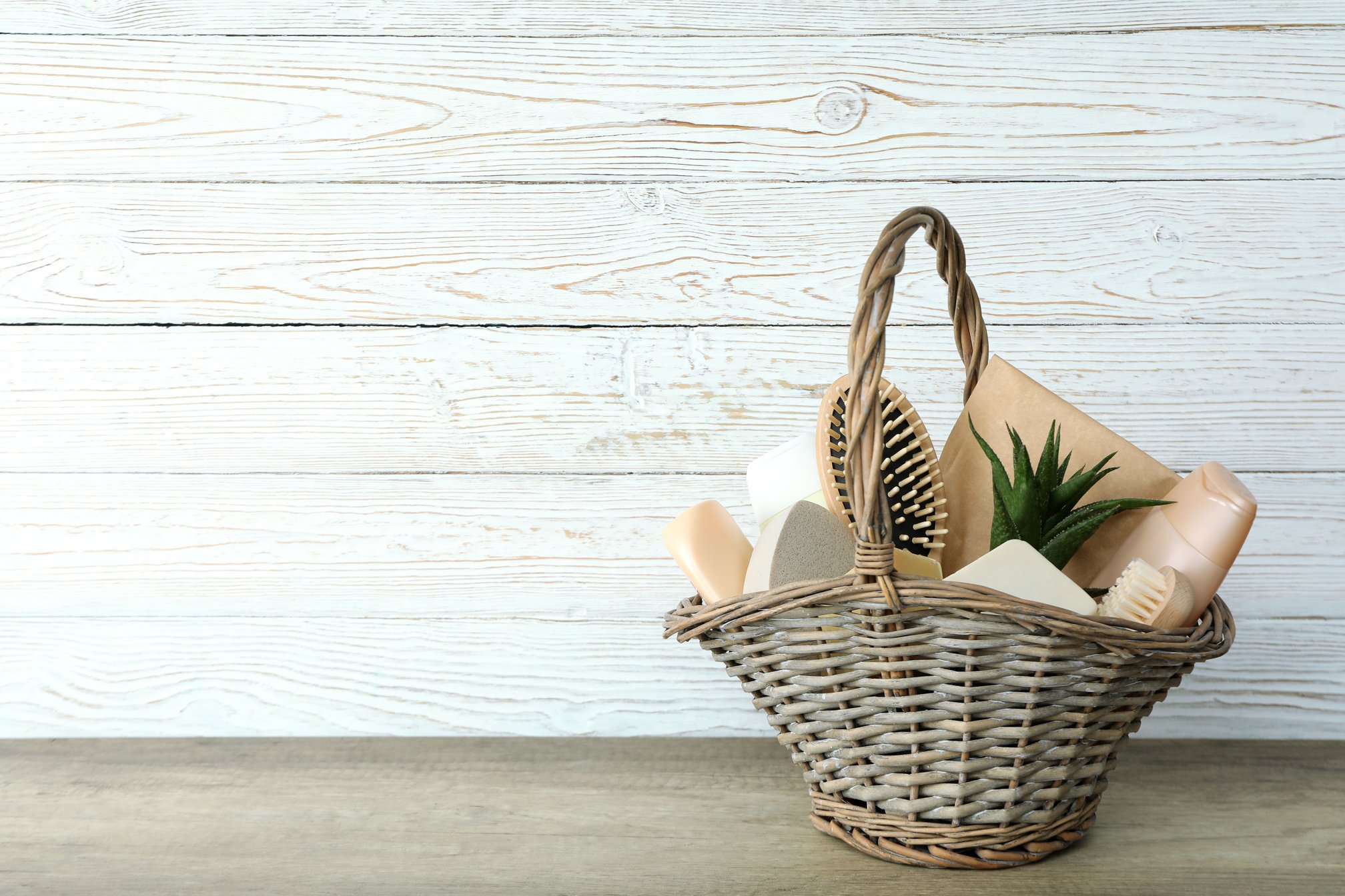 Gift basket with cosmetics on textured table